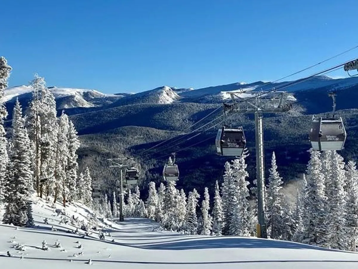 This exterior image captures ski gondolas gliding above snow-covered trees with a dramatic mountain backdrop. The scene is infused with energy and anticipation, evoking the thrill of winter adventures like skiing and snowboarding. The expansive view highlights the natural beauty and recreational opportunities of Winter Park.